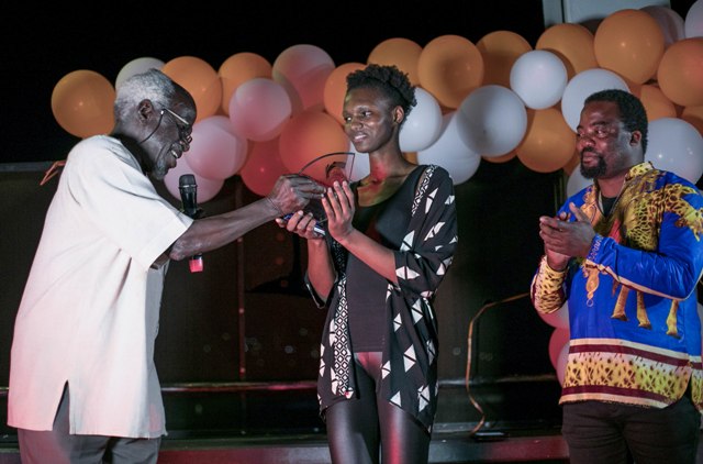 L-R-Prof.-Taban-Lo-Liyong-handing-over-the-Koffi-Addo-Prize-for-Creative-Nonfiction-to-Chisanga-Mukuka-as-one-of-the-2018-judges-Shadreck-Chikoti-looks-on-in-Kampala.-Photo-by-EUGENE-KAV